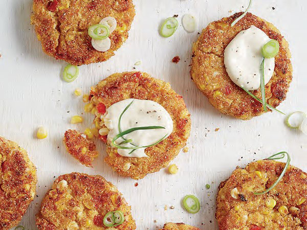 Fried corn cakes topped with aioli, and chopped green onions